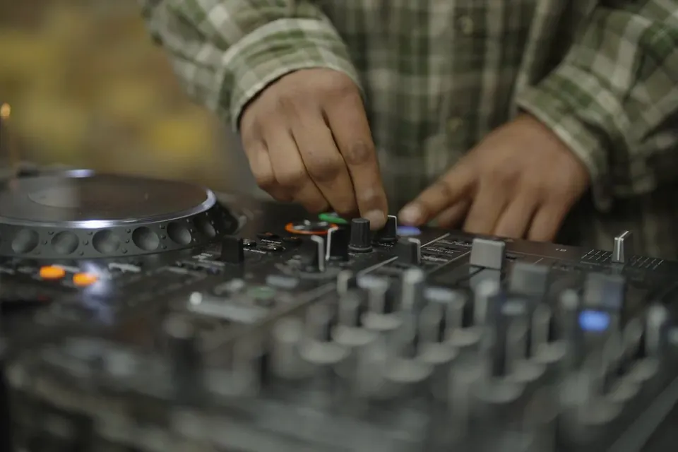 Hands on the mixing desk in the Brixton Radio studio