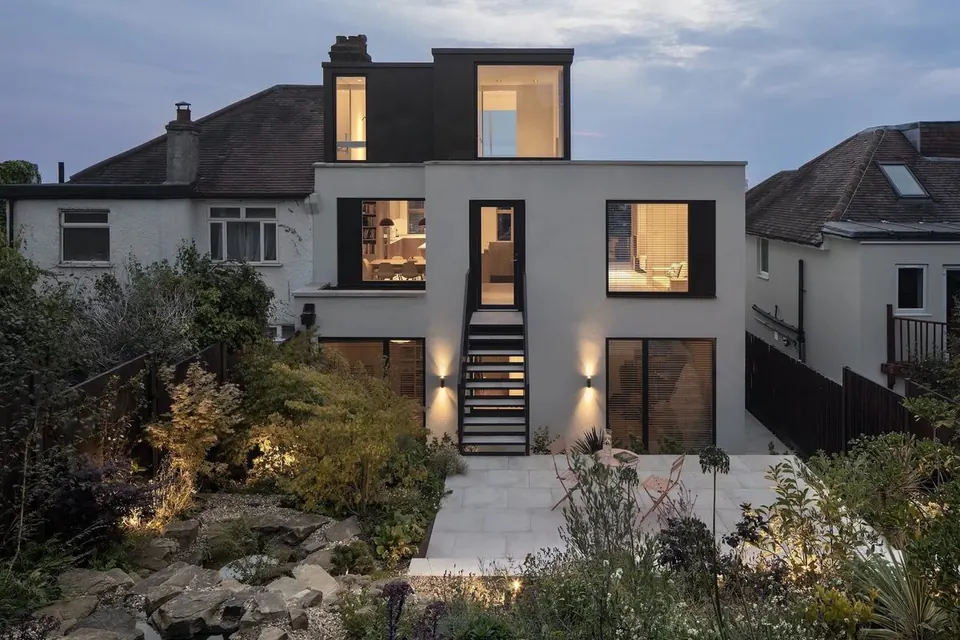 A contemporary white house at dusk, designed by David Money Architects