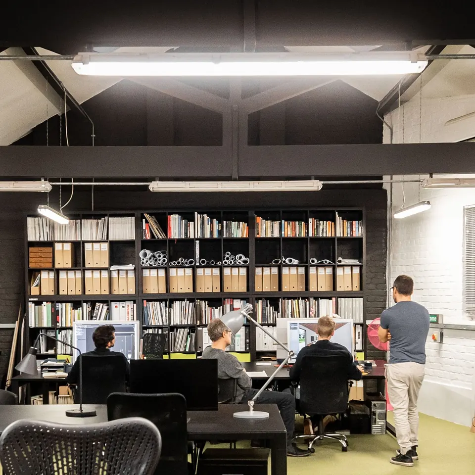 Rows of desks beneath full-height black bookshelves
